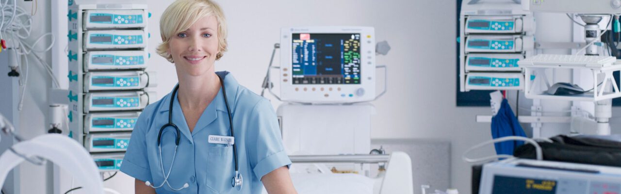 ICU Nurse sitting on hospital bed surrounded by equipment