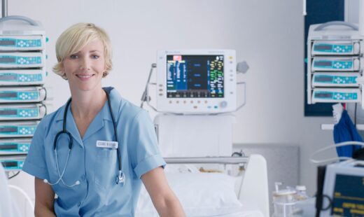 ICU Nurse sitting on hospital bed surrounded by equipment